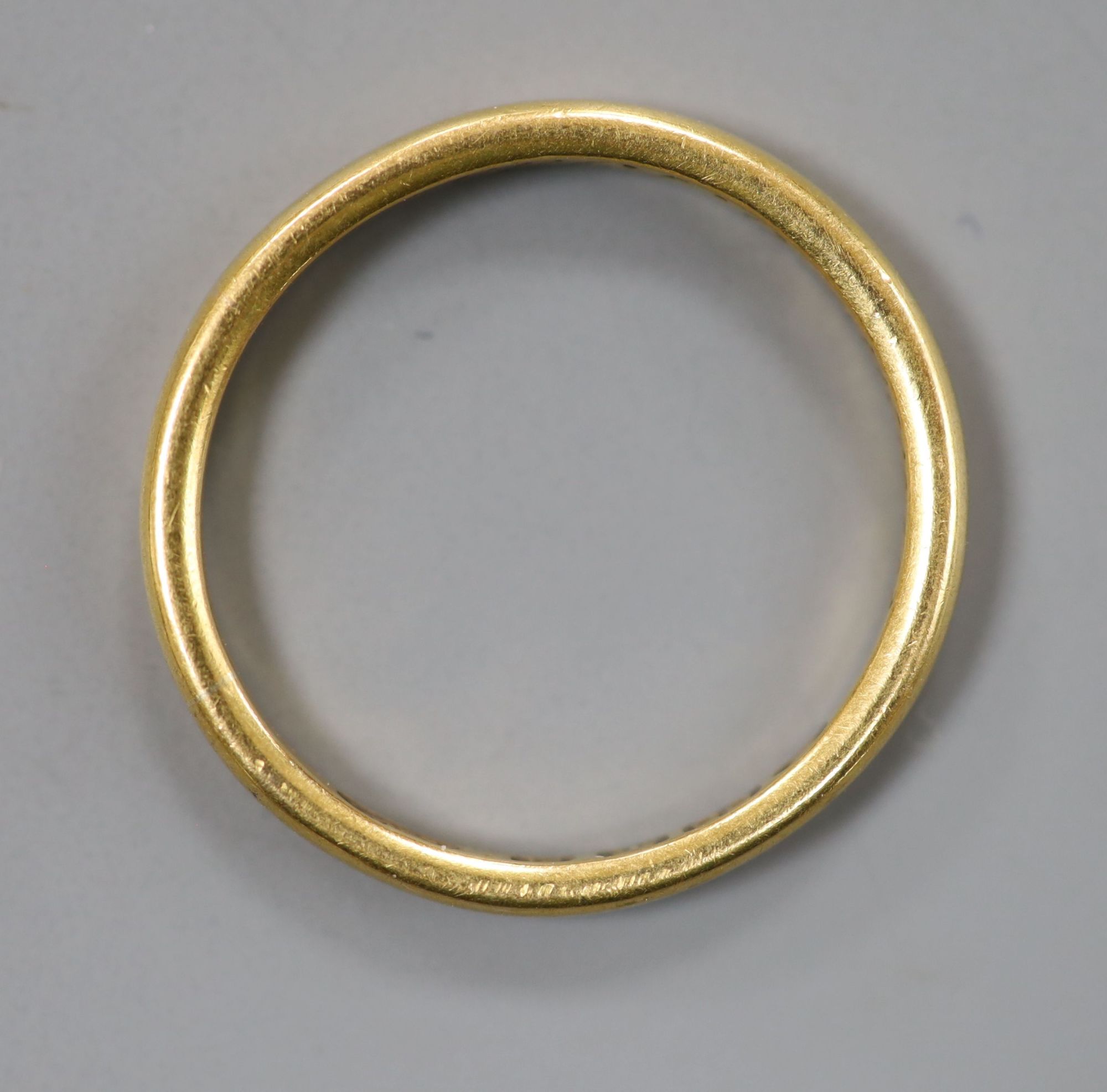 An Edwardian 22ct gold wedding band, with engraved inscription, size O, 3.6 grams.